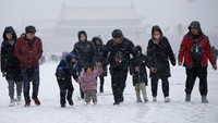 Cerianya anak-anak bermain salju di Tiananmen Square di Beijing, China. Jason Lee/Reuters.