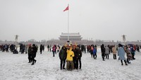 Sejumlah warga berfoto bersama saat salju turun. Jason Lee/Reuters.