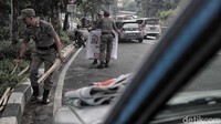 Satpot PP menyusuri jalan untuk menertibkan baliho yang dipasang sembarangan.