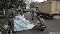 Baliho yang ditertibkan itu dipasang menggunakan bambu dan ditancapkan di pinggir jalan.