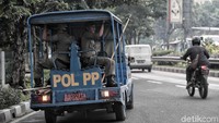 Mobil Satpol PP menyusuri jalanan di kawasan Sunter untuk menertibkan baliho yang dipasang sembarangan.