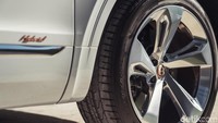 Ada logo hybrid di bodi samping mobil. Mobil diperkuat dengan motor listrik dan mesin 3.0 liter V6 turbo. Motor listriknya berfungsi sebagai motor penggerak dan generator. Foto: Bentley