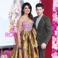 Sementara itu, Nick Jonas memilih setelan berwarna hijau zaitun yang dipadu dengan boots suede coklat.  Foto: Getty Images