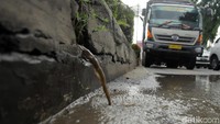Air merembes dari sungai ke jalan.
