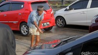 Dengan keadaan kaki yang cacat ia berjalan menghampiri tiap pengendara.