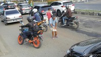Pengemis itu menyusuri jalanan yang ramai oleh kendaraan.