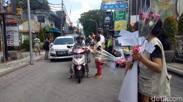 Sambil bagi-bagi bunga mawar, KPU Badung, Bali, mengajak pemilih muda agar tak golput.
