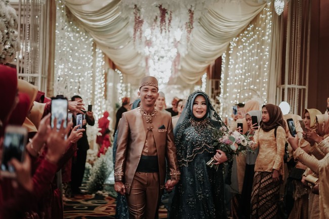 Pada acara resepsi, ia mengenakan busana bernuansa emerald. Gaun bertabur payet cantik itu dibuat senada dengan veil yang ia kenakan. Foto: Mezzo Photo / Instagram @mezzophotoupdate