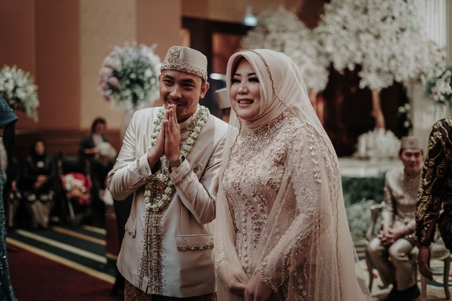 Saat akad nikah, Risa tampil cantik mengenakan busana bernuansa nude. Ia memakai kebaya modern bertabur payet yang dipadukan dengan kain batik. Foto: Mezzo Photo / Instagram @mezzophotoupdate