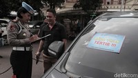 Petugas mendata pemilik mobil yang parkir sembarangan di halaman Polda Metro Jaya.