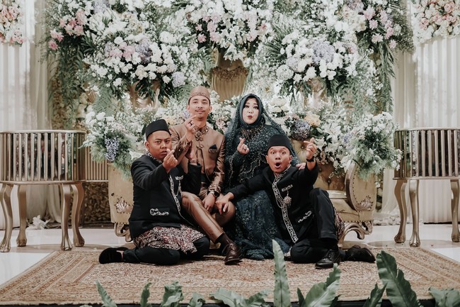 Risa kembali memilih hijab segi empat berwarna dengan gaya sederhana. Berbeda dari kebanyakan pasangan pengantin, sang suami Dimas Tri Adityo memakai busana bernuansa cokelat. Foto: Mezzo Photo / Instagram @mezzophotoupdate