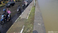 Air mengalir dari trotoar hingga ke jalan.