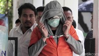 Ia tampak mengenakan baju berlapis dengan hoodie, masker dan juga topi untuk menutupi wajahnya.