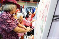 Kartika Affandi melukis bersama anak dengan Down Syndrome.