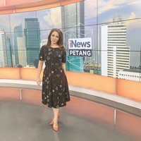 Dress hitam selalu bisa diandalkan untuk bekerja. Untuk tampilan yang lebih atraktif, Anisha pun memakai high heels warna oranye muda yang menambah sentuhan segar dalam penampilan.  Foto: Instagram @anishadasuki
