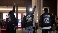 Para pendukung capres nomer urut 01 mengenakan jaket dan berpose di depan luar arena debat Hotel Sultan Jakarta.