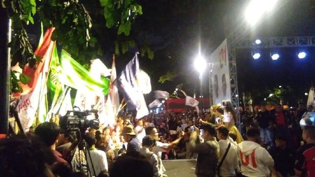 Pendukung Jokowi-Ma'ruf mengibarkan bendera di lokasi nobar di Parkir Timur Senayan.