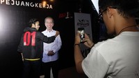 Salah satu pendukung capres nomer 01 berfoto di wall a fame bertulisakan pejuang kerja dan foto Jokowi. Foto: dok. Kita Satu