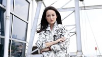 Julie tampil kasual dengan celana hitam, jaket dan blus putih.