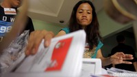 Masing-masing pegawai diberikan beberapa surat suara untuk dilipat dan kemudian disortir.