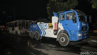 Mobil derek mulai mengevakuasi bus TransJ.