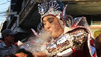 Seorang peserta memberikan berkat kepada penari barongsai yang ikut ambil bagian dalam acara Hei Neak Ta. Heng Sinith/AP Photo.
