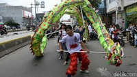 Naga liong barongsai pun menari-nari di jalan.
