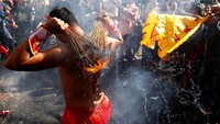 Salah seorang peserta menempelkan api pada punggungnya di tengah acara Hei Neak Ta. Samrang Pring/Reuters.