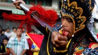 Salah seorang peserta menampilkan aksi ekstrem saat ikut serta dalam acara Hei Neak Ta di Kamboja. Samrang Pring/Reuters.
