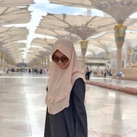 Kevin tampil sederhana saat beribadah umrah. Ia mengenakan khimar instan dan gamis berwarna netral. Saat ibadah umrah, kita dianjurkan untuk memakai busana yang tidak terlalu mencolok. Foto: Instagram/kevinlln