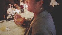 Mengenakan baju abu-abu, Nadien terlihat tengah memegang minuman coktail dingin.  Foto: Instagram@nadinemmanuella