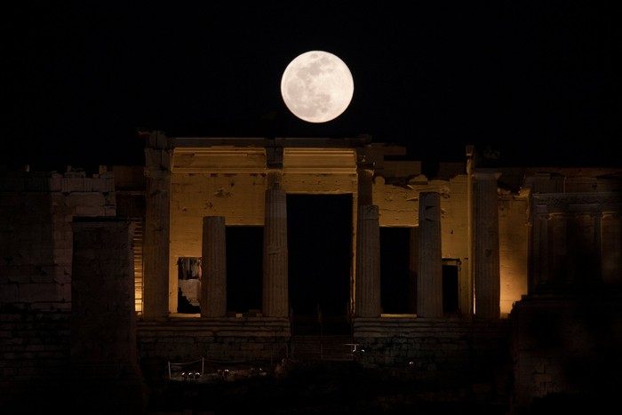 A super snow moon is seen rising between clouds from the walk Muelle Uno in Malaga, southern Spain February 19, 2019. REUTERS/Jon Nazca