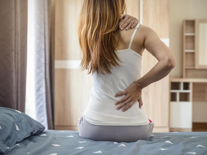 nyeri leher Woman suffering from back ache on the bed, healthcare and problem concept