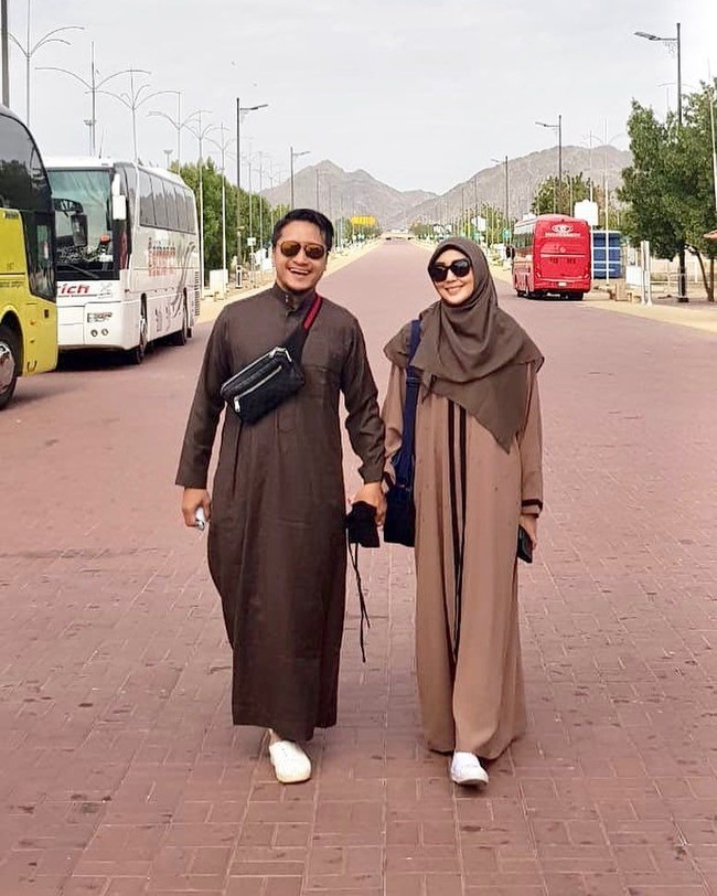 Saat berjalan-jalan, Fenita tidak terlihat memakai cadar. Ia kembali memilih warna netral yaitu cokelat muda yang serasi dengan suaminya Arie Untung. Foto: Instagram/FenitaArie