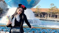 Plesir ke Tokyo, Bella terlihat berpose di DisneyLand. Senyum manis Bella dilemparkan sambil memegang sekantung popcorn. Foto: instagram @bellalunaferlinn