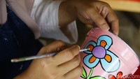Kaleng-kaleng bekas ini dilukis dengan berbagai motif, seperti motif bunga ini.