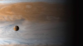 Bulan Io dengan latar belakang planet Jupiter. Foto: NASA