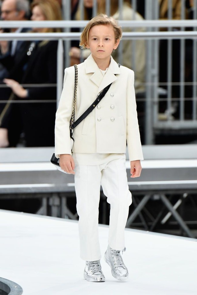 Karl Lagerfeld juga menghadirkan sosok pria sebagai muse favoritnya. Dia adalah Hudson Kroenig, yang tidak lain adalah anak baptisnya sendiri. Bocah 11 tahun ini sering kali tampil bersama Karl Lagerfeld di final fashion show. Hudson adalah model cilik, anak dari model pria yang juga jadi musel Chanel, Brad Kroenig. Foto: Getty Images