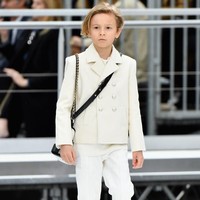 Karl Lagerfeld juga menghadirkan sosok pria sebagai muse favoritnya. Dia adalah Hudson Kroenig, yang tidak lain adalah anak baptisnya sendiri. Bocah 11 tahun ini sering kali tampil bersama Karl Lagerfeld di final fashion show. Hudson adalah model cilik, anak dari model pria yang juga jadi musel Chanel, Brad Kroenig. Foto: Getty Images