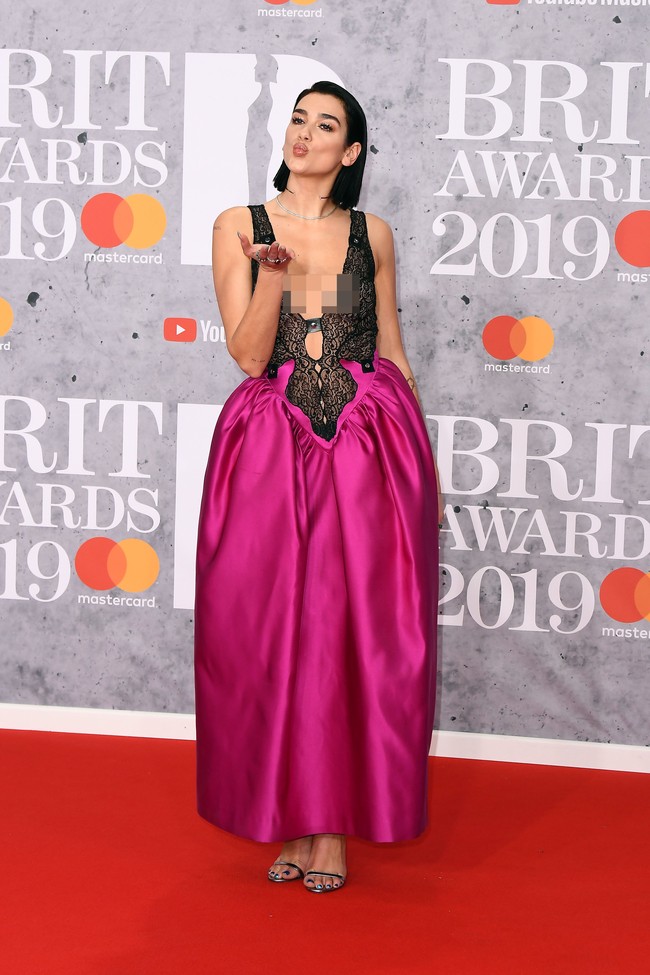 Sementara roknya bervolume dengan warna fuchsia yang mencolok sehingga memberi kesan jenaka pada penampilannya. Ia lalu menyempurnakan gayanya dengan sandal heels bergaya minimalis dan hair-do yang slick. Foto: Getty Images