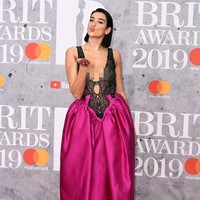 Sementara roknya bervolume dengan warna fuchsia yang mencolok sehingga memberi kesan jenaka pada penampilannya. Ia lalu menyempurnakan gayanya dengan sandal heels bergaya minimalis dan hair-do yang slick. Foto: Getty Images