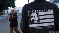 Seorang peserta aksi Kamisan mengenakan pakaian dengan wajah aktivis Munir Said Thalib sebagai gambarnya. Munir merupakan salah satu aktivis yang tewas tanpa diketahui pasti siapa pelaku yang menjadi otak pembunuhan tersebut.
