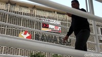 Warga melintasi JPO dengan latar belakang layar digital hitung mundur Pemilu 2019.