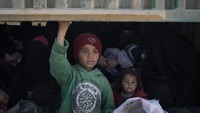 Para wanita dan anak-anak dimasukkan ke dalam truk untuk dievakuasi ke kamp-kamp pengungsian sebelum pasukan Aliansi Pasukan Demokratik Suriah (SDF) melancarkan serangan ke kantong pertahanan terakhir ISIS. Felipe Dana/AP Photo.