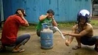 Ada cara ampuh nih untuk membubarkan kerumunan massa. Bermodalkan sebuah tabung gas, tiga orang pria berpose seperti sedang akan menyalakan petasan. Foto: Istimewa
