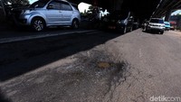 Sejumlah kendaraan melintas di Jalan DI Panjaitan yang berlubang di kawasan Jakarta Timur, Jumat (22/2/2019).