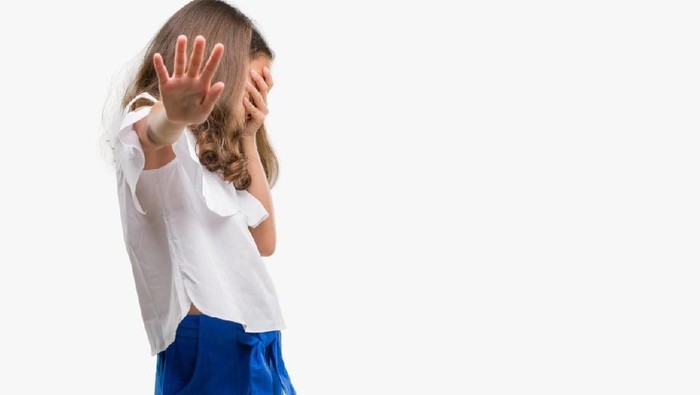 Brunette hispanic girl covering eyes with hands and doing stop gesture with sad and fear expression. Embarrassed and negative concept.