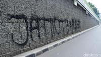 Aksi vandalisme ini mengotori dinding jalur busway koridor 13.
