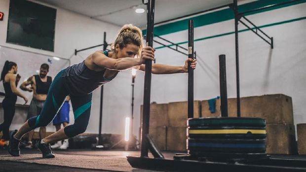 fitness gemuk obesitas olahraga Strong young woman pushing heavy weights at the gym
