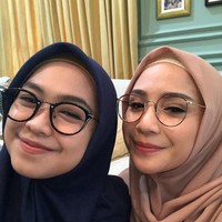 Nagita Slavina juga pernah tampil berhijab saat foto selfie dengan Ria Ricis. Gigi memakai hijab segi empat warna nude, dilengkapi dengan inner rajut warna senada. Sedangkan Ria Ricis memakai hijab segi empat warna biru dongker. Keduanya kompak mengenakan kacamata. Foto: Instagram/RiaRicis.